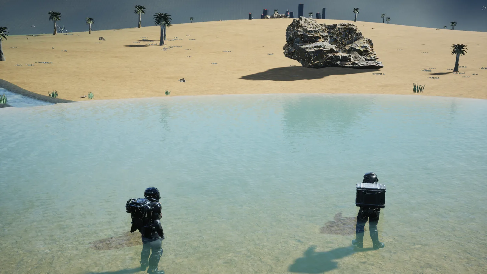 Two explorers wade into Wayfarer Pond below a dune